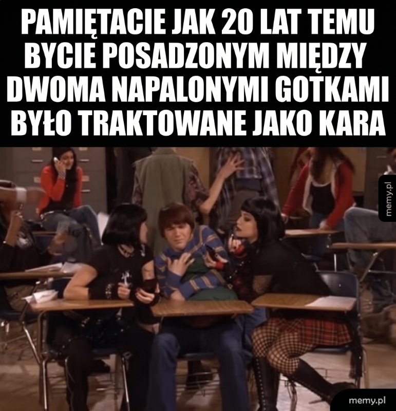Grupa osób w szkolnej klasie, dwie dziewczyny rozmawiają z chłopakiem.