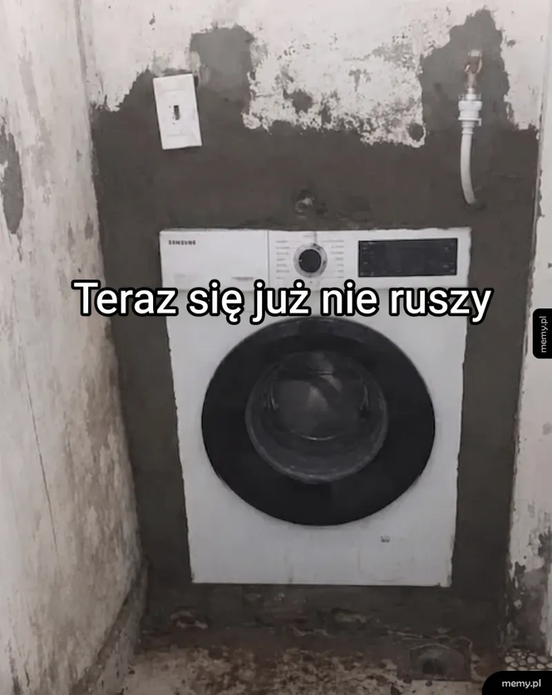 Pralka w ścianie z cementem wokół.