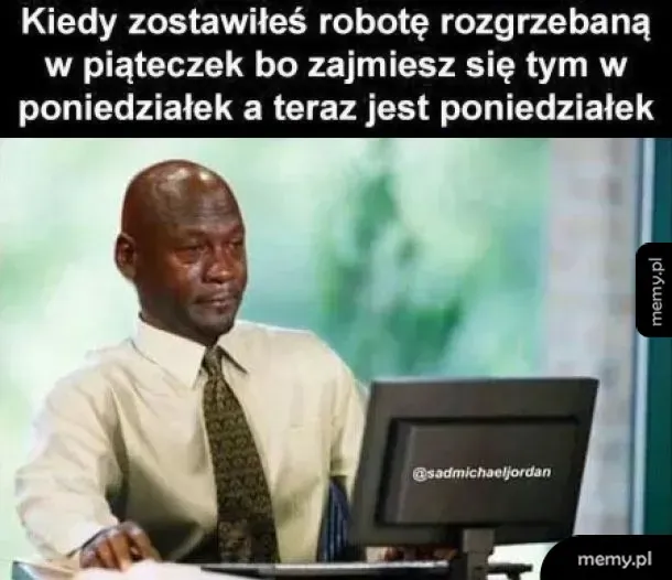 Mężczyzna z wyrazem smutku siedzi przy biurku, patrząc w dół.