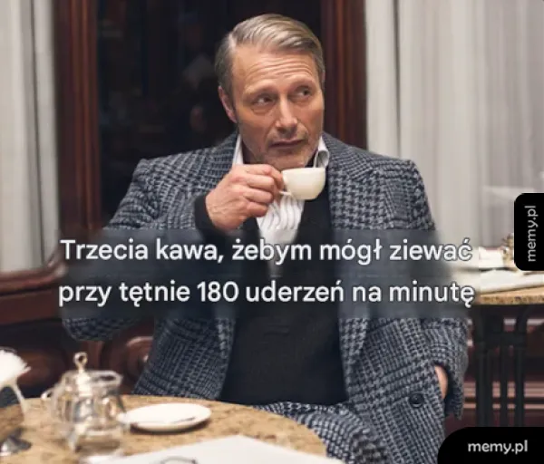 Mężczyzna w eleganckim ubraniu pije kawę w luksusowej kawiarni.
