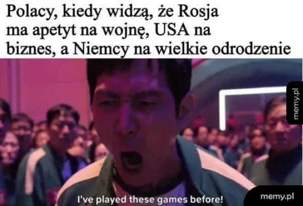 Mężczyzna krzyczy w tłumie, z intensywnym wyrazem twarzy.
