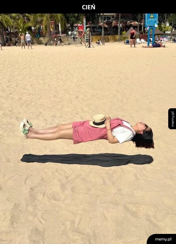 Kobieta śpiąca na plaży obok dziwnego, podłużnego cienia.
