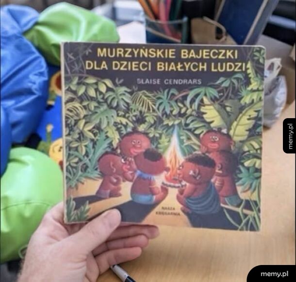 Ręka trzymająca starą książkę z kontrowersyjnym tytułem i ilustracją wokół ogniska.